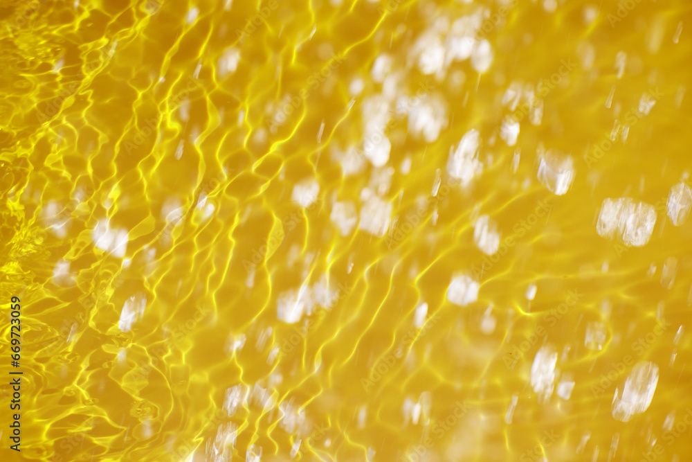 Defocus blurred transparent gold colored clear calm water surface texture with splashes reflection. Trendy abstract nature background. Water waves in sunlight with copy space. Yellow watercolor shine. Defocus blurred transparent gold colored clear calm water surface texture with splashes reflection. Trendy abstract nature background. Water waves in sunlight with copy space. Yellow watercolor shine.