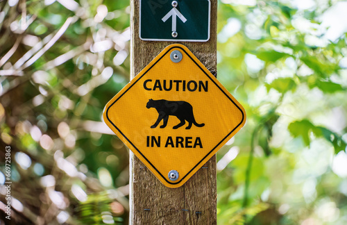 Warning sign cougar is in the forest area near city Vancouver