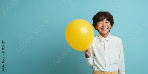 happy asian boy with yellow balloon, happy childhood, space for text