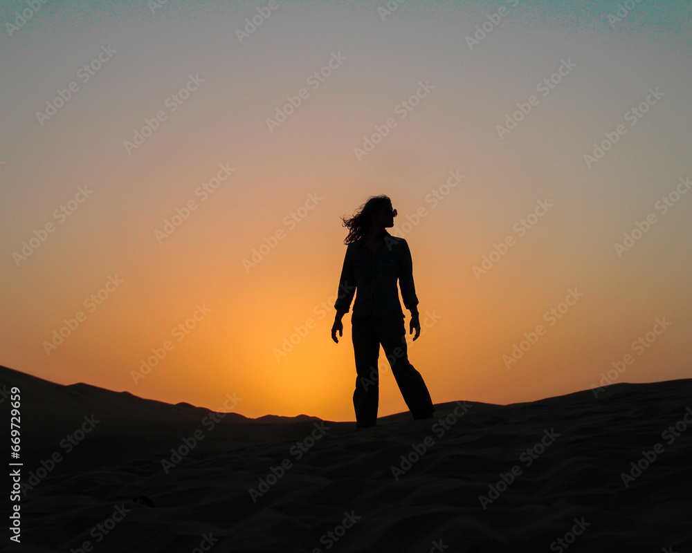 silhueta de mulher em por do sol nas dunas de huacachina, peru 