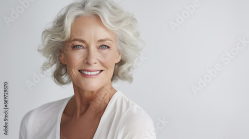 An Elderly Mature Woman wearing white is isolated against a white background with copy space, beautiful and confident