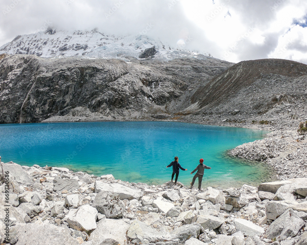 Naklejka premium casal de braços erguidos em frente a laguna 69, no parque nacional huascarán, no peru 