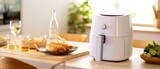 White air fryer or oil free fryer appliance on the wooden table with cement wall kitchen