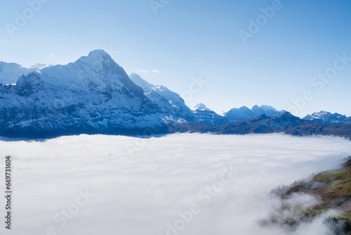Mountain scenery. View of the valley with clouds and mountain peaks. Nature. Place for trekking and tourism. Landscape in the Alps, Europe. Photo for wallpaper or background.