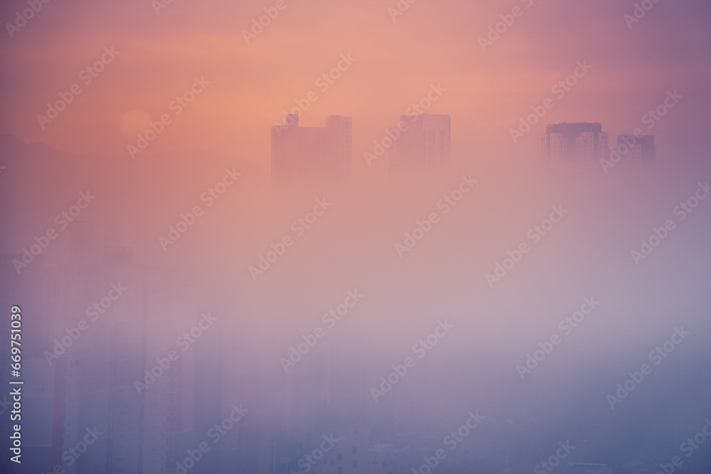 Sunrise over Daegu City skyline, tips of the skyscrapers floating over the morning fog and smog in South Korea, minimalist impressionistic photo Sunrise over Daegu City skyline, tips of the skyscrapers floating over the morning fog and smog in South Korea, minimalist impressionistic photo