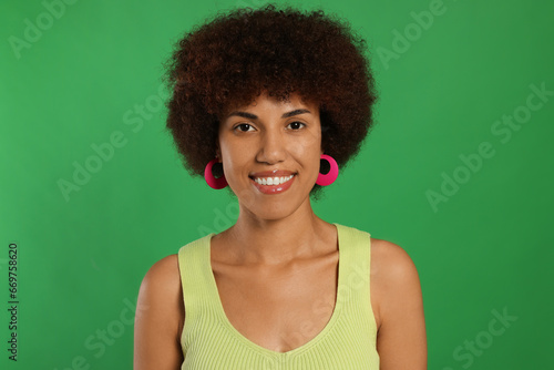 Portrait of happy young woman on green background