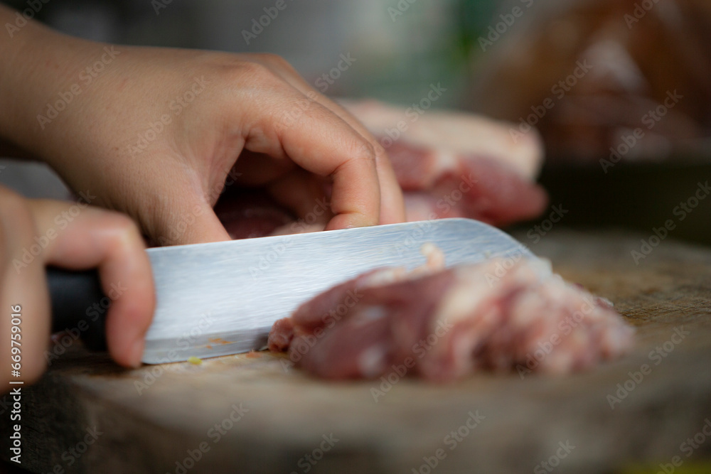 Cutting pork with a knife, close-up, selective focus