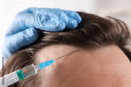 Trichologist giving injection to patient in clinic, closeup