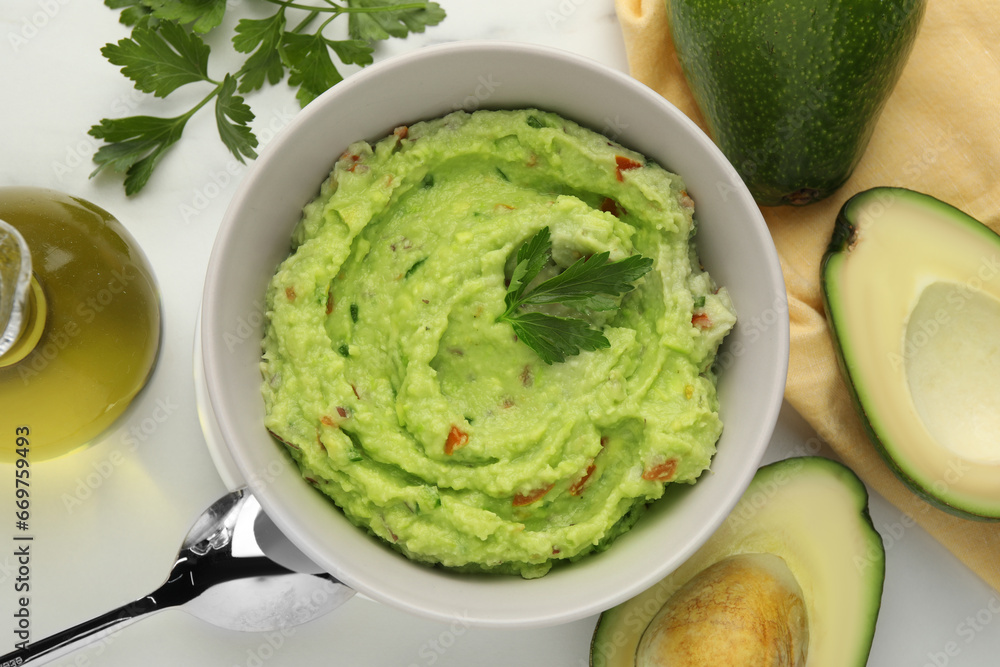 Obraz premium Delicious guacamole and ingredients on white table, flat lay