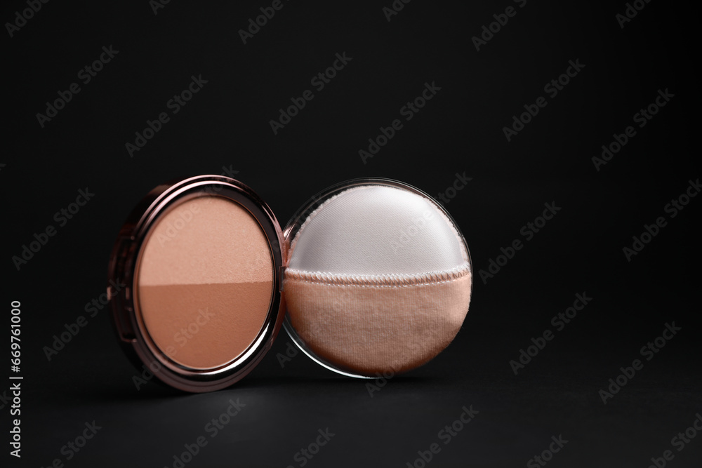 Open face powder with puff applicator on black background, closeup Open face powder with puff applicator on black background, closeup