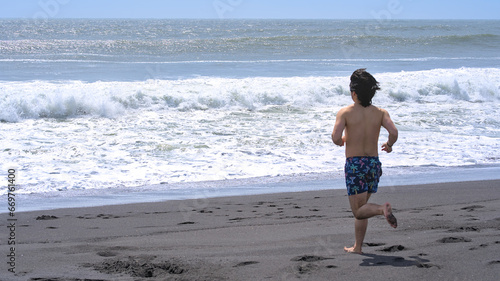 Young man running to the watter of pacific ocean (Constitucion, Chile)