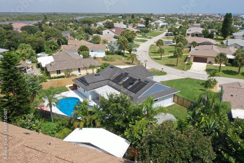Aerial of Daytona Beach area residential neighborhood, featuring a home with an in-ground swimming pool and solar panels on the roof. 