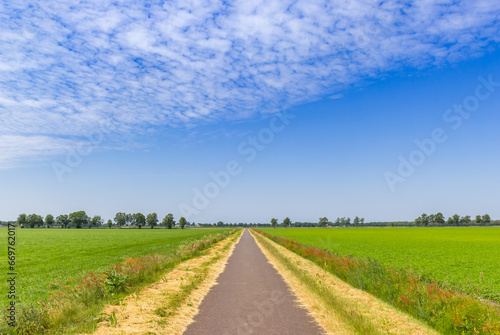 Straight road going through the flat landscape of Drenthe, Netherlands