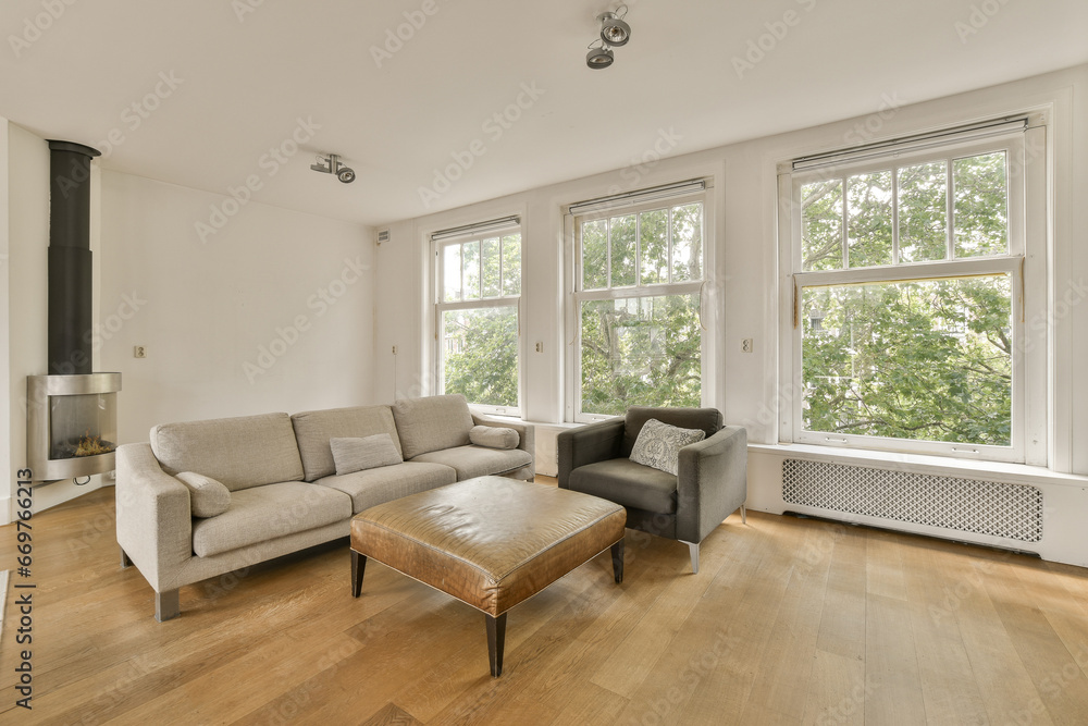 a living room with wood flooring and large windows looking out onto the trees in the photo is taken from inside a living room with wood flooring and large windows looking out onto the trees in the photo is taken from inside