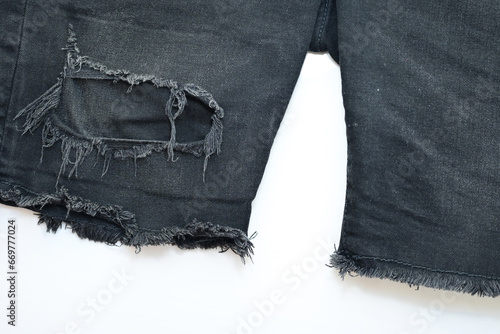 torn black danim texture on white background, textile of jeans fashion for clothing design photo