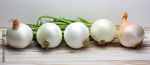 Four sweet white onions arranged on rustic wood