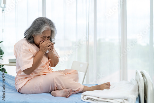 Fotografie Elderly Asian patient admitted to hospital She had a violent cough while sitting on the hospital bed