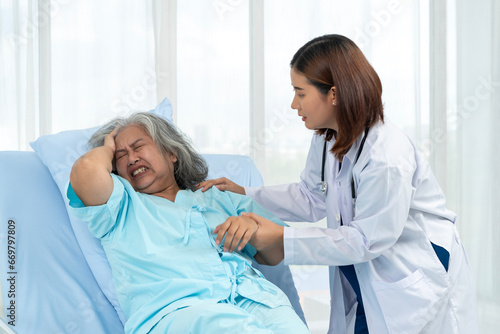A neurologist treats an elderly female patient who is holding her head in pain. from acute pain from a cerebral ischemic stroke