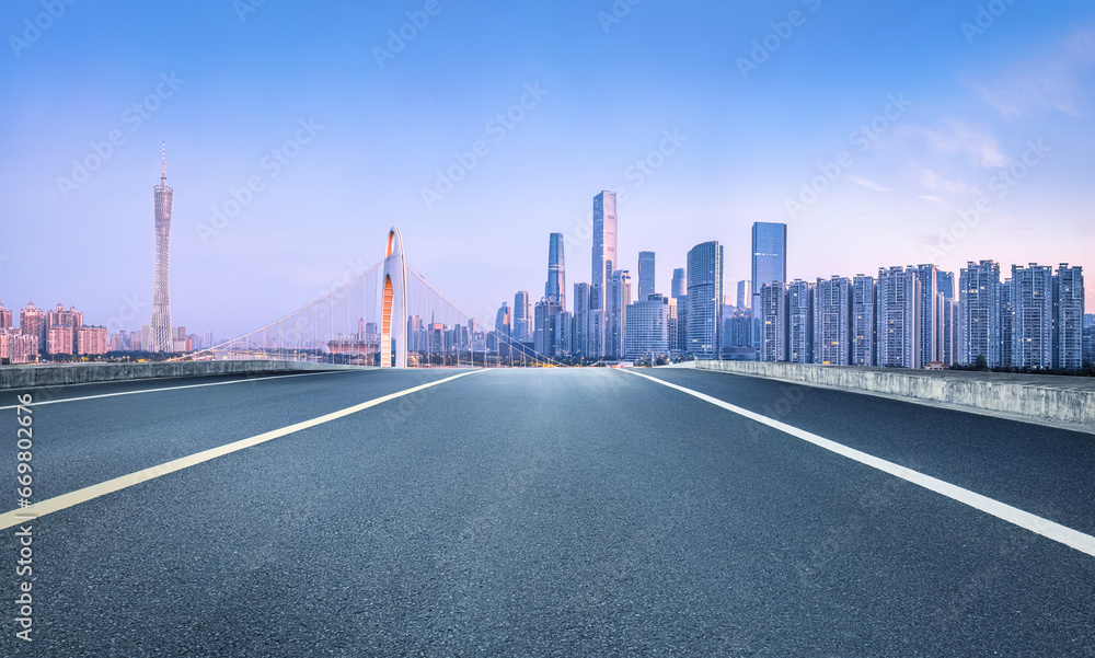 Asphalt road and city commercial buildings skyline in Guangzhou at dusk