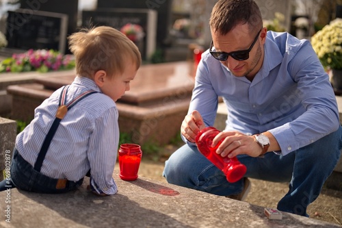 Valokuva Father and son lighting a candle at the grave