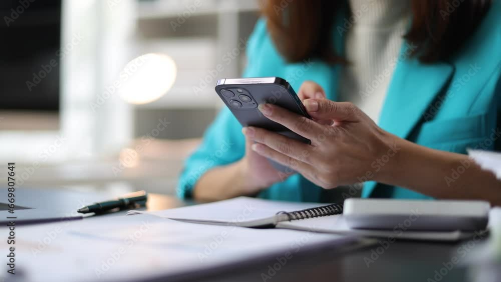 Businesswoman working in the home office is using mobile phone to send messages and chat with colleagues. Businesswoman working in the home office is using mobile phone to send messages and chat with colleagues.