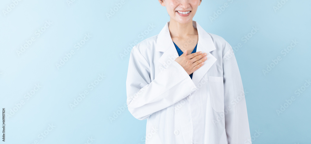 胸に手を当てる女性の医者・ブルーバック