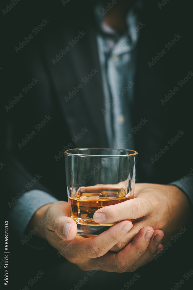 Close-up businessman holding a glass of whiskey