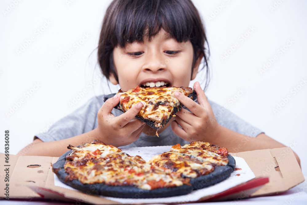 Hungry little girl enjoys Italian pizza alone on a white background