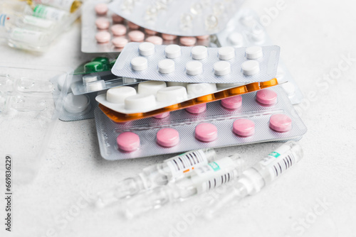 Pile of various pills and tablets in a blister pack on white background, healthcare and medicine concept