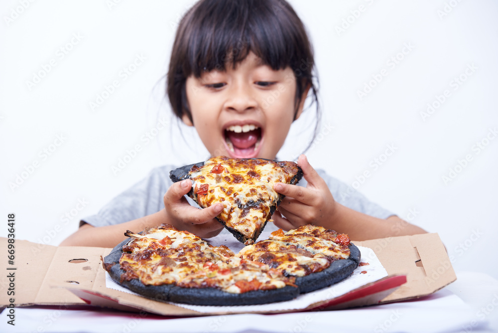 Hungry little girl enjoys Italian pizza alone on a white background
