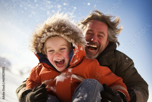 Dad and son happily sled down the hill