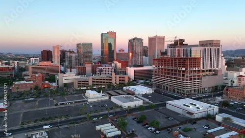 Sunset over Phoenix, Arizona skyline. Cinematic aerial establishing shot of downtown skyscrapers. photo