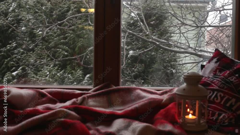 New Year Christmas background with frosty window and falling snow in the background. Warm homely mood