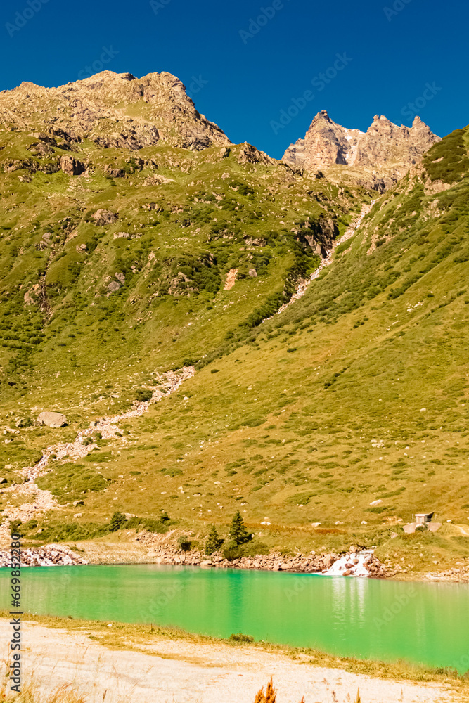 Alpine summer view with reflections in a lake at Vermunt reservoir, Sylvretta-High-Alps-Street, Vorarlberg, Tyrol, Austria