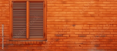 Wooden shutters on an orange brick wall with a window © AkuAku