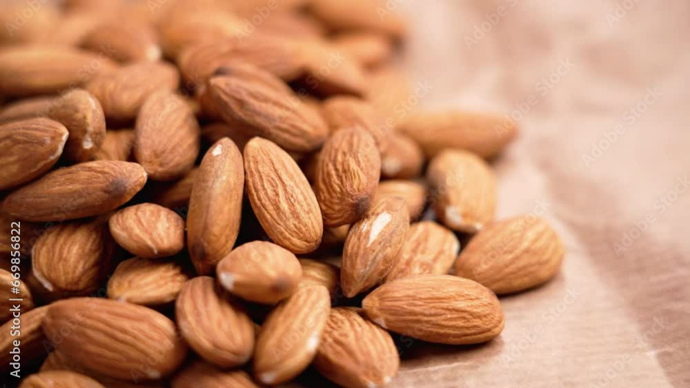 Dried dieting almonds nuts on a brown wrapping paper close up. Rotation Dried dieting almonds nuts on a brown wrapping paper close up. Rotation