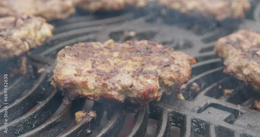 Closeup shot of grilling beef burgers on a portable charcoal grill Closeup shot of grilling beef burgers on a portable charcoal grill