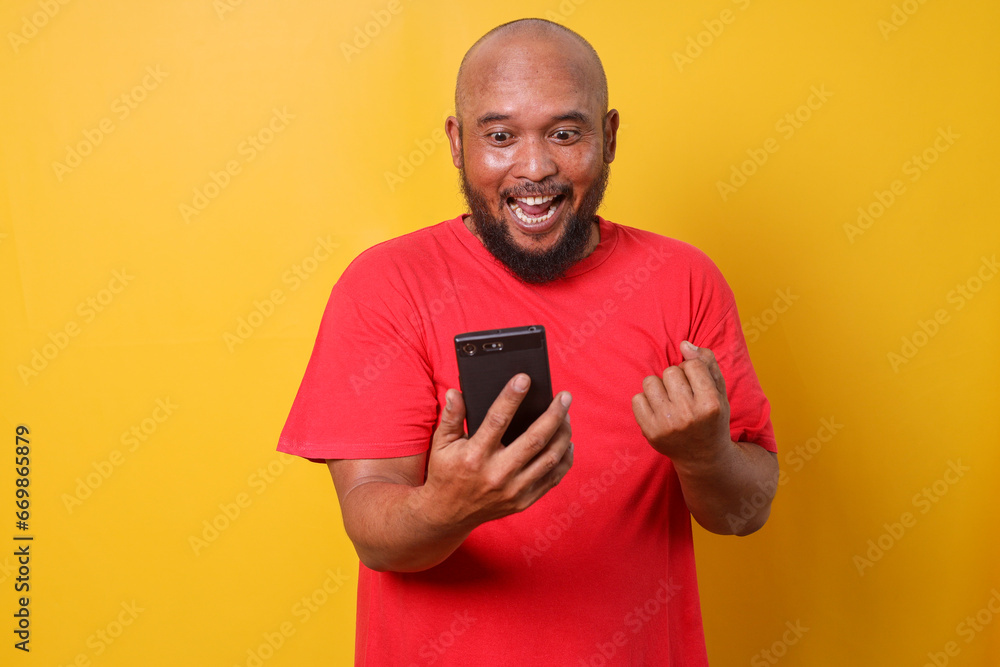 Excited bald bearded man using smartphone winning game, getting cashback online gift in mobile app message Excited bald bearded man using smartphone winning game, getting cashback online gift in mobile app message