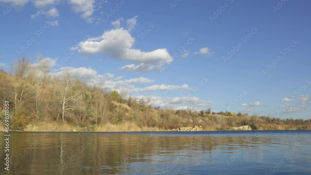 Autumn calm landscape. River bank, trees with fallen leaves, blue sky with clouds. Autumn calm landscape. River bank, trees with fallen leaves, blue sky with clouds.