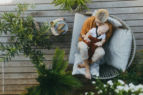 Vászonkép Top view of beatiful mother sitting with little son outdoors, in garden patio