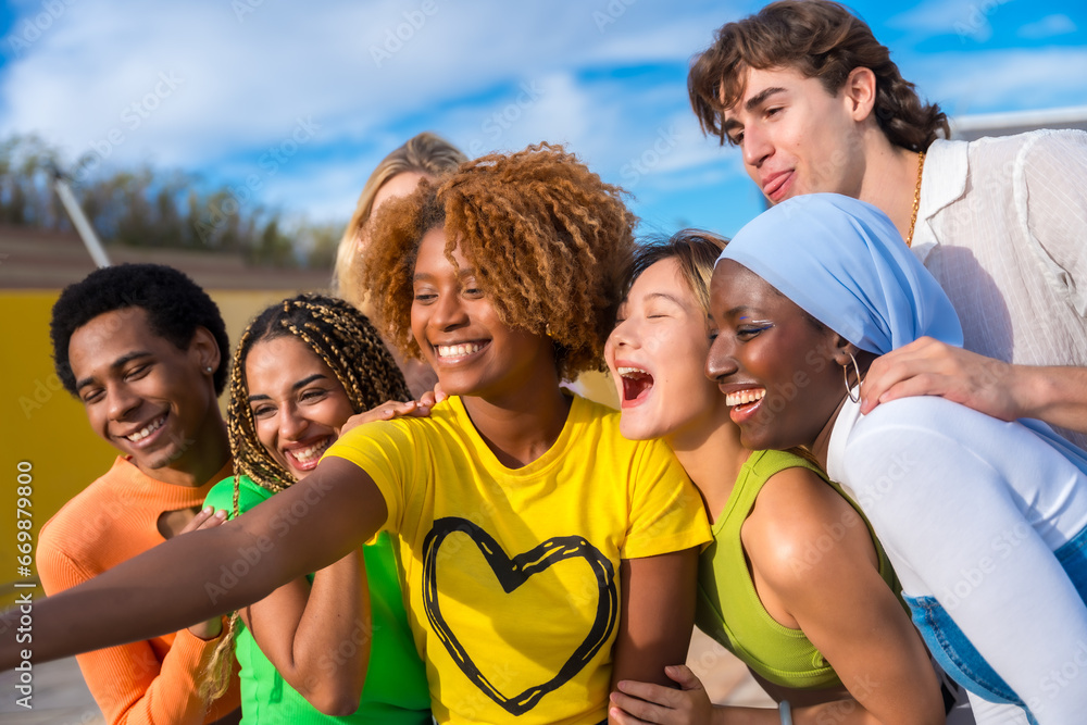 Multi-ethnic friends smiling and taking a selfie outdoors