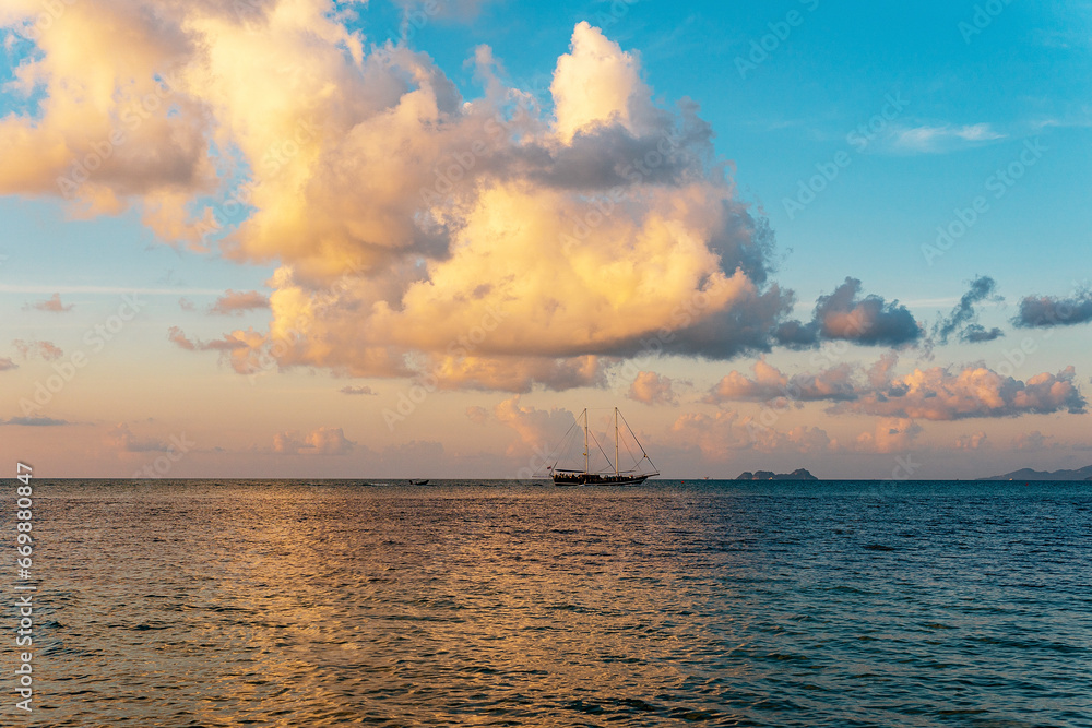 A stunning sunset low-key panoramic view of a boat in the sea. 