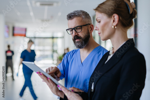 Pharmaceutical sales representative talking with doctor in medical building. Ambitious female hospital director consulting with healtcare staff. Woman business leader. photo