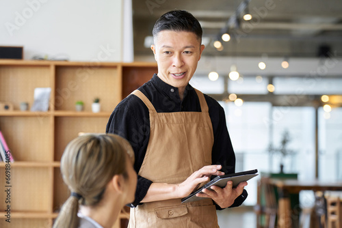 カフェで注文を取るアジア人男性店員 photo