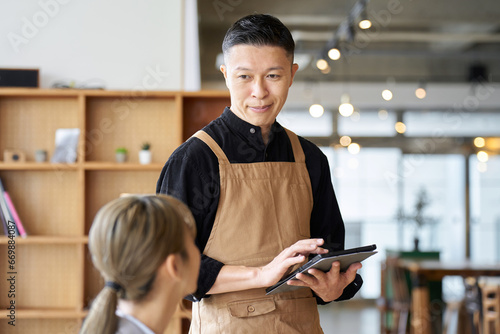 カフェで注文を取るアジア人男性店員 photo