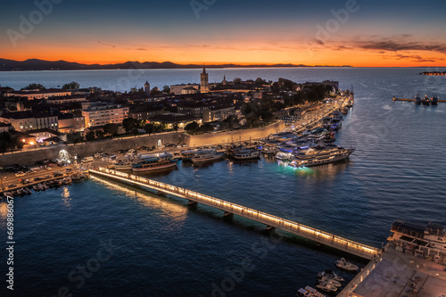 Zadar, Croatia - Aerial view of the old town of Zadar at golden sunset sky with illuminated City Bridge (Gradski most), Cathedral of St. Anastasia tower and yacht marina