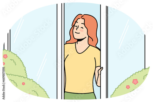 Happy girl looks out of window, rejoices in rays of sun, flowering vegetation in spring outside. Young woman enjoying summer sunny day standing in open door. Vector thin line isolated illustration.