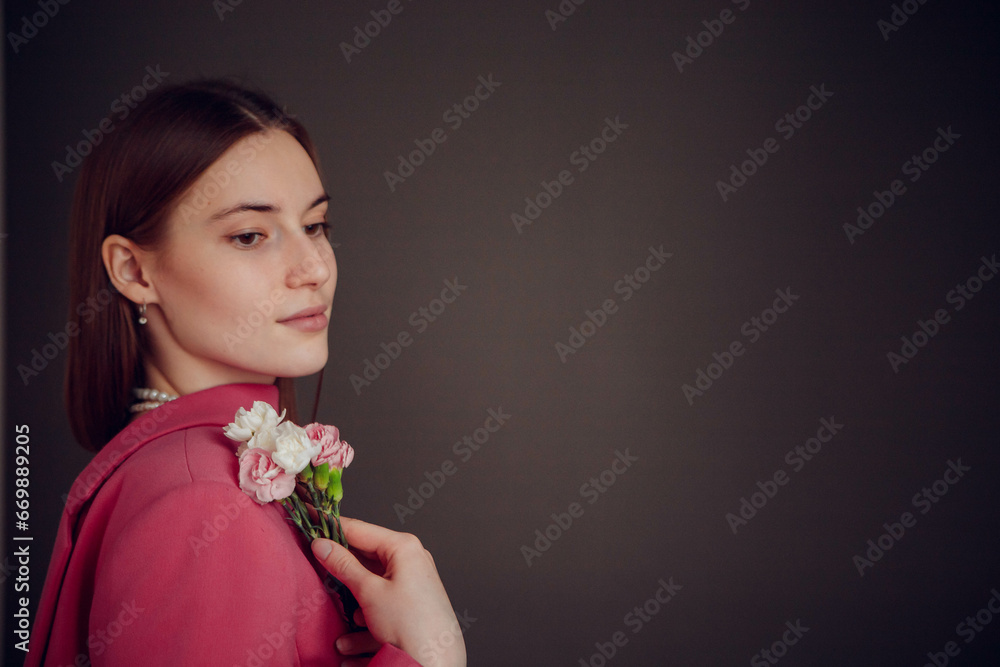 Young beautiful girl posing with flowers in the studio Young beautiful girl posing with flowers in the studio