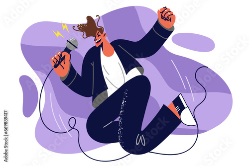 Man singer with microphone in hands jumps up speaking to audience on stage and enjoys singing