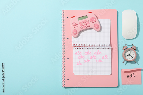 Notepads, alarm clock, joystick and note on blue background, space for text